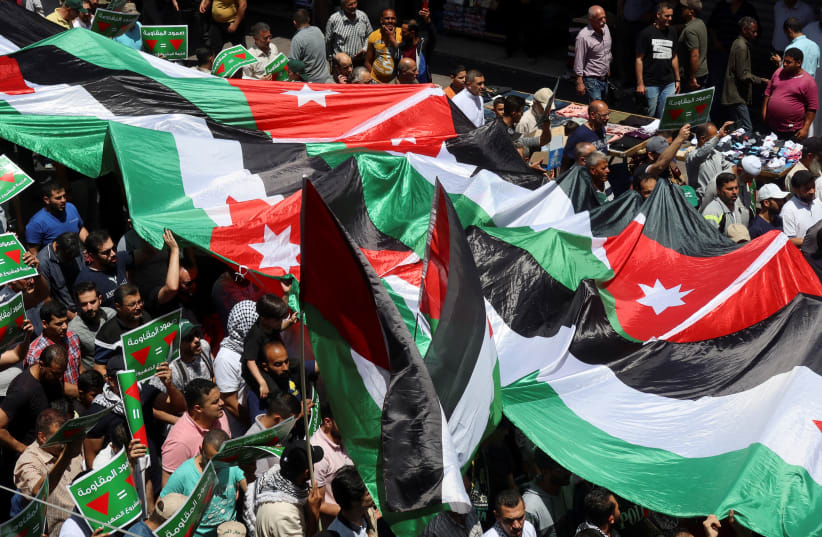  Manifestantes portan banderas y pancartas durante una protesta en apoyo a los palestinos de Gaza, en medio del actual conflicto entre Israel y el grupo islamista palestino Hamás, en Ammán, Jordania, 24 de mayo de 2024. (photo credit: REUTERS/JEHAD SHELBAK)