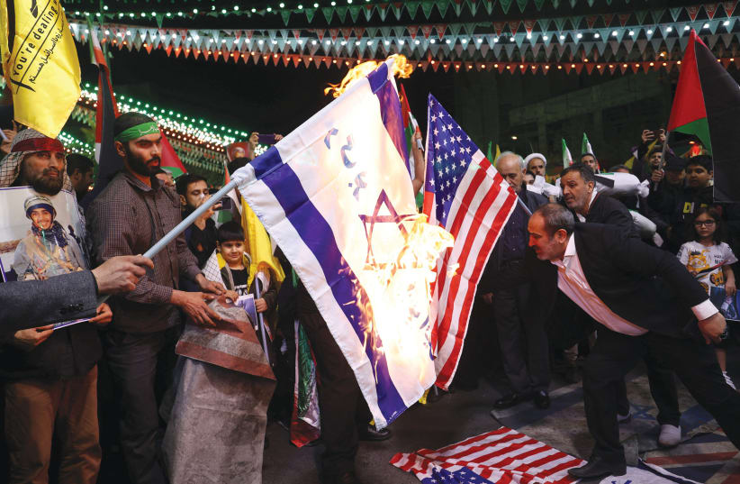  PROTESTERS BURN an Israeli and a US flag in Tehran, earlier this year. The Iranian cyber threat is especially troubling for the Jewish Diaspora, which Iran targets as part of its broader agenda, encapsulated in its chilling slogan: ‘Death to America, Death to Israel,’ says the writer.  (photo credit: WEST ASIA NEWS AGENCY/REUTERS)