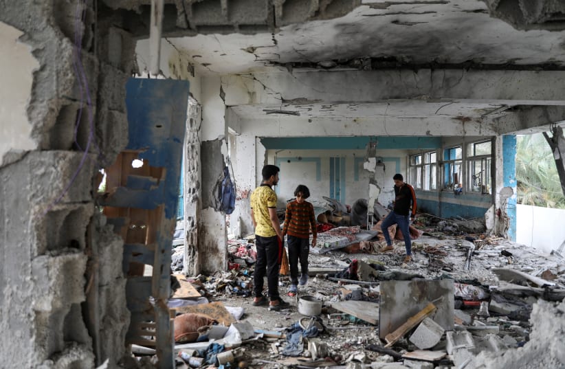  Palestinians inspect the site of an Israeli strike on a UNRWA school sheltering displaced people, amid the Israel-Hamas conflict, in Nuseirat refugee camp in the central Gaza Strip, June 6, 2024.  (photo credit: REUTERS/Abed Khaled)