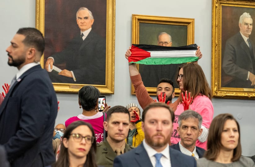  Protesters from the group Code Pink gesture as US Defense Secretary Lloyd Austin and the Chairman of the Joint Chiefs of Staff General Charles Brown, Jr. testify before a House Appropriations Defense Subcommittee hearing, April 17, 2024.  (photo credit: REUTERS/KEN CEDENO)