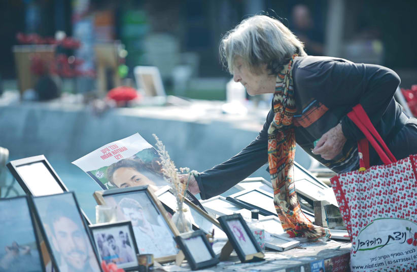  A WOMAN pauses at a display of photos of those murdered or still held hostage by Hamas in Gaza since the October 7 massacre, at Dizengoff Square in Tel Aviv. (photo credit: TOMER NEUBERG/FLASH90)