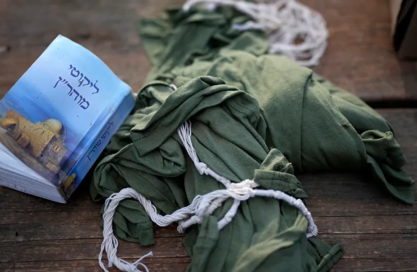  A soldier's prayer book and army-issued tzitzit are seen at a staging area near the border with Gaza, Nov. 15, 2023.  (photo credit: Christopher Furlong/Getty Images)