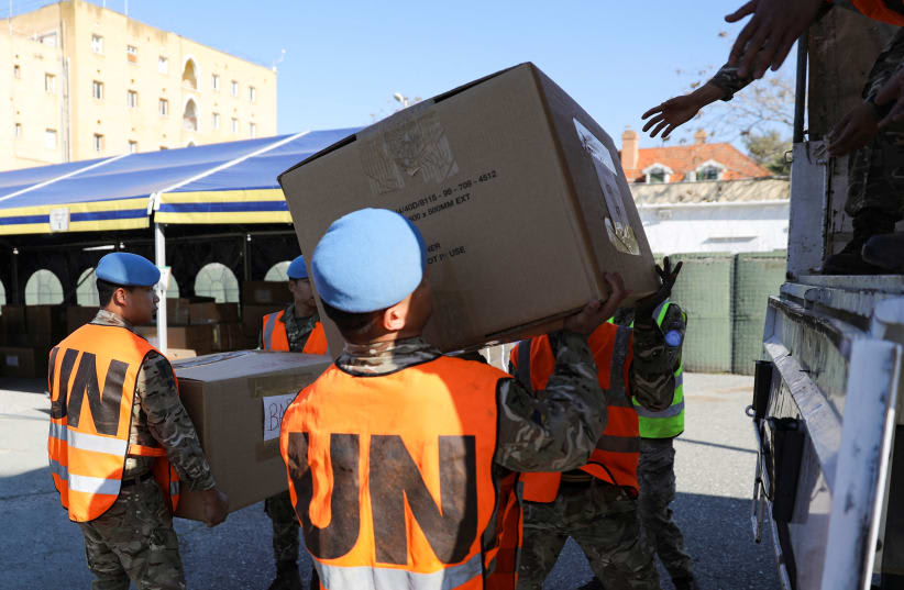  Las fuerzas de paz de la ONU cargan cajas de alimentos, ropa, agua y mantas en un camión, donado por grecochipriotas para su distribución a las víctimas del terremoto en Turquía, en el Palacio de Ledra dentro de la zona de amortiguación de la ONU en Nicosia, Chipre, 15 de febrero de 2023. (photo credit: YIANNIS KOURTOGLOU/REUTERS)