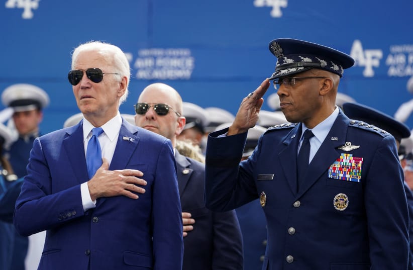 US President Joe Biden puts his hand on his heart during the national anthem, accompanied by Charles “CQ” Brown, US chairman of the Joint Chiefs of Staff, during the graduation ceremony at the Air Force Academy in Colorado Springs, Colorado, US, June 1, 2023. (photo credit: REUTERS/KEVIN LAMARQUE)