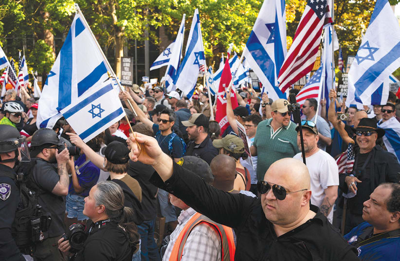  Demonstrators at a pro-Israel rally hold flags in front of a protest encampment in support of Palestinians in Gaza at  the University of Washington in Seattle on May 12.  (photo credit: David Ryder/Reuters)