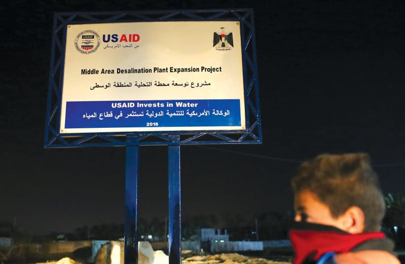  A sign of a USAID project is seen in the central Gaza Strip. (photo credit: IBRAHEEM ABU MUSTAFA/REUTERS)