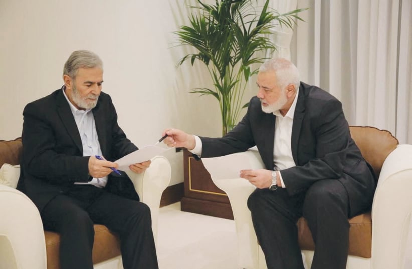  HAMAS LEADER Ismail Haniyeh (right) and Islamic Jihad leader Ziyad al-Nakhalah discuss a ceasefire proposal before responding to Qatari and Egyptian mediators in Doha, earlier this month.  (photo credit: Hamas Media Office/Reuters)