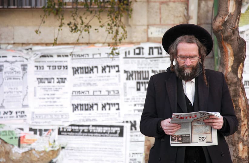  A haredi man reads a newspaper in Jerusalem’s Mea She’arim neighborhood. (photo credit: MARC ISRAEL SELLEM)