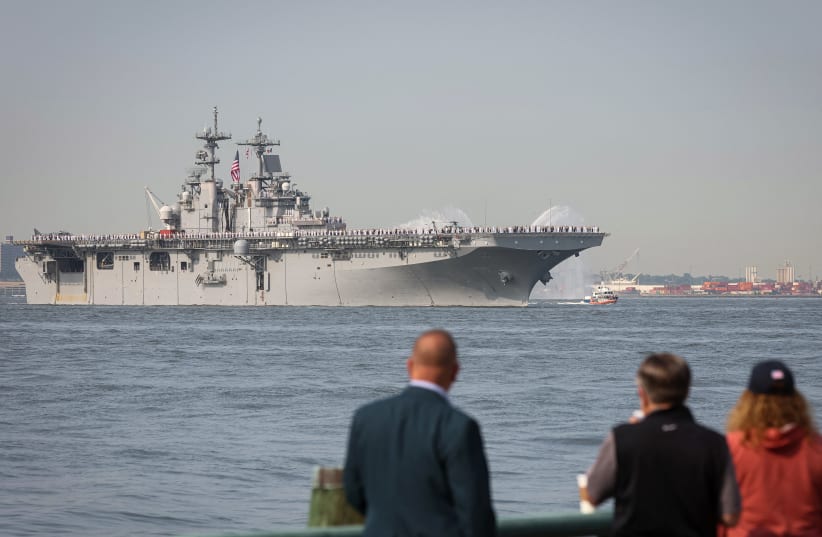  People watch as Sailors and Marines line the deck of the USS Wasp, an amphibious assault ship, as it arrives in New York Harbor during the parade of ships to kick off "Fleet Week 2023" in New York City, U.S., May 24, 2023. (photo credit: REUTERS/BRENDAN MCDERMID)