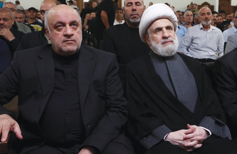  HEZBOLLAH DEPUTY leader Sheikh Naim Qassem (right) and Iran’s Ambassador to Lebanon Mojtaba Amani attend a memorial service for Taleb Abdallah, a Hezbollah senior commander killed in an Israeli strike in Lebanon, last month. (photo credit: MOHAMED AZAKIR/REUTERS)