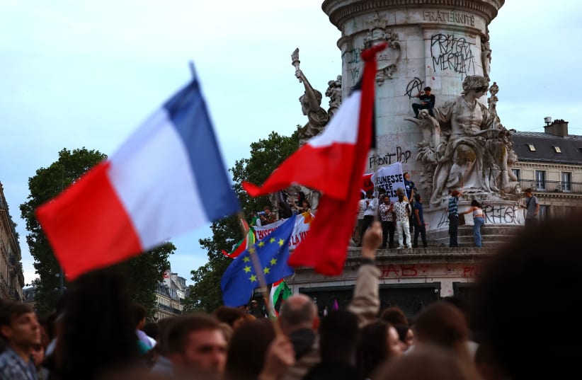  People hold French national flags as they gather to protest against the French far-right Rassemblement National (National Rally - RN) party, at the Place de la Republique following partial results in the first round of the early 2024 legislative elections, in Paris, France, June 30, 2024.  (photo credit: REUTERS/FABRIZIO BENSCH)