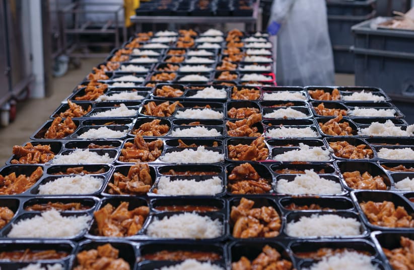  COOKED MEALS are prepared for distribution. NIS 2.7 billion worth of food, enough to feed hundreds of thousands, will be wasted in Israel this holiday season, the writer laments.  (photo credit: AMIR YAKOBY)