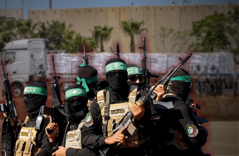  Hamas terrorists against backdrop of humanitarian aid trucks. (illustration) (photo credit: REUTERS/Hatem Khaled, Flash90)