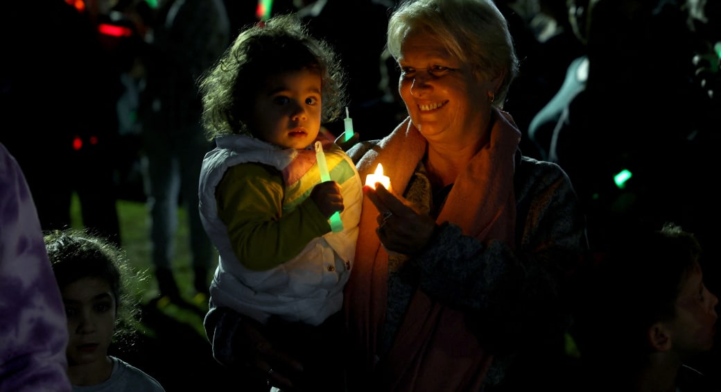  Displaced community members from Kibbutz Kfar Aza, which was hit hard following the deadly October 7 attack by gunmen from Palestinian militant group Hamas from the Gaza Strip, light Hanukkah candles and call for release of all hostages during a ceremony at Kibbutz Shefayim, Israel December 10, 202 (photo credit: RONEN ZVULUN/REUTERS)