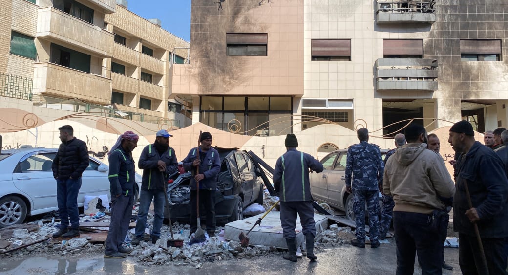  Workers and people stand near a damaged building after, according to Syrian state media reports, several Israeli missiles hit a residential building in the Kafr Sousa district, Damascus, Syria February 21, 2024 (photo credit: REUTERS/FIRAS MAKDESI)