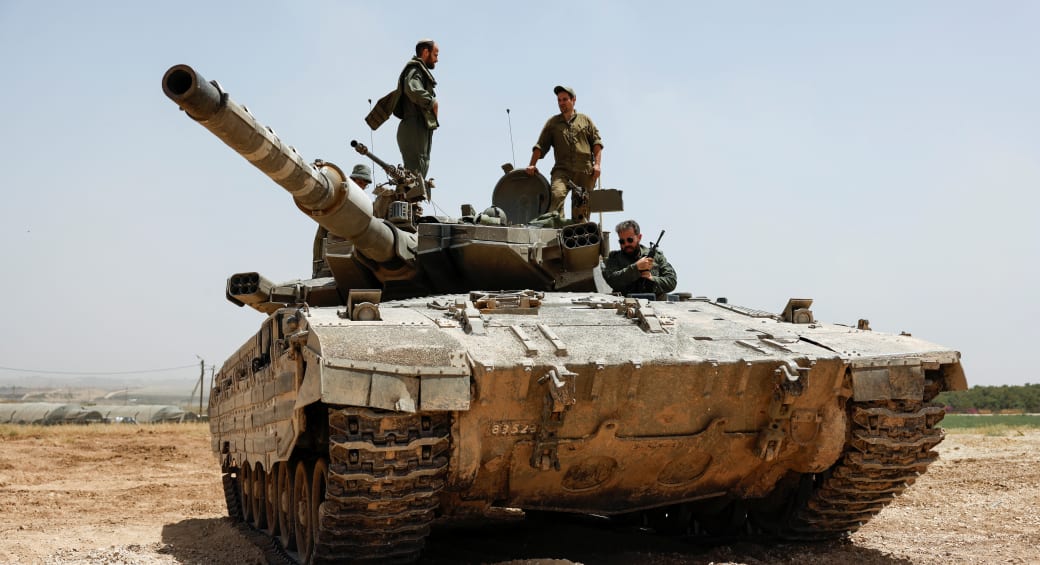  IDF soldiers operate atop a tank near the Gaza border, as seen from Israel, May 21, 2024 (photo credit: REUTERS/AMIR COHEN)