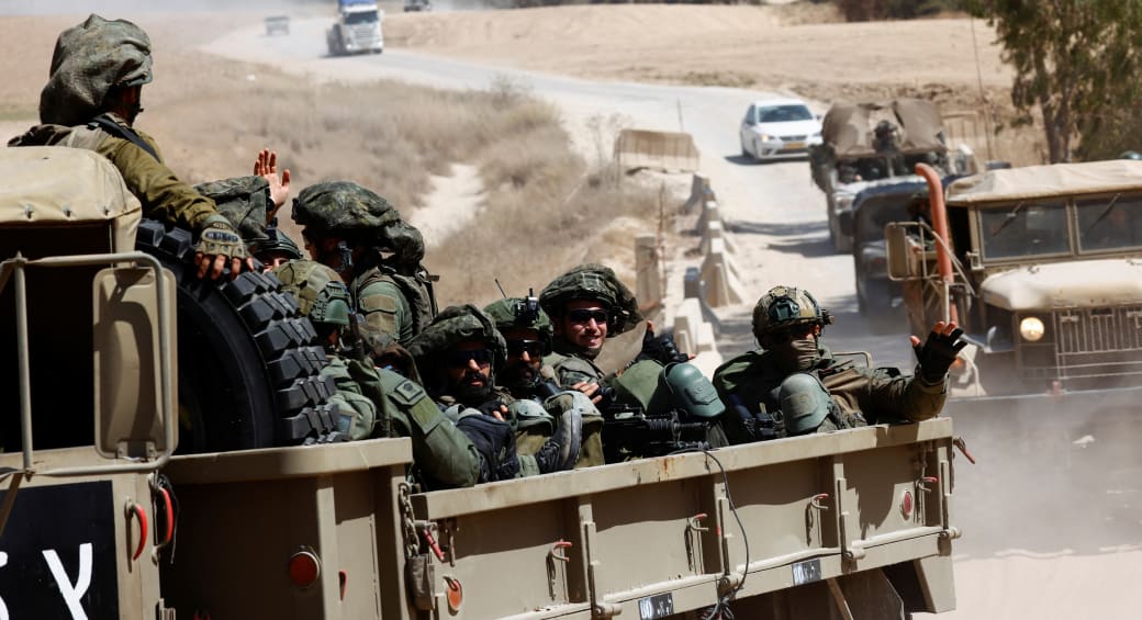  Israeli soldiers gesture from a military truck as it maneuvers near Gaza border, June 10, 2024 (photo credit: AMIR COHEN/REUTERS)
