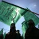  Masked Hamas men wave flags during the march in Jabalya refugee camp in North Gaza Strip, October 4, 2002