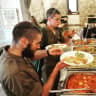 Two American lone soldiers dish-up food during a Friday buffet at Piccolino restaurant in Jerusalem. 