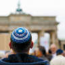 A MAN wearing a kippa waits for the start of a demonstration against antisemitism at Berlin’s Brandenburg Gate in 2014