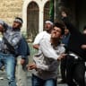 Palestinians hurl rocks at Israeli security forces during clashes in the West Bank town of Hebron October 16, 2000.