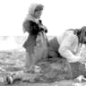 An Armenian woman kneeling beside a dead child in a field “within sight of help and safety at Aleppo.”