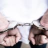Male hands arrested with handcuffs in Criminal concept (illustrative)