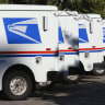U.S. postal service trucks sit parked at the post office in Del Mar, California