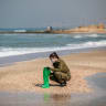 Israeli soldiers clean tar off the Palmachim beach following an offshore oil spill which drenched most of the Israeli coastline, February 22, 2021