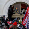 A mob of supporters of then-US President Donald Trump climb through a window they broke as they storm the US Capitol Building in Washington, US, January 6, 2021.