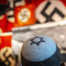  Visitors seen standing next to a display of swastika banners at the Yad Vashem Holocaust Memorial museum in Jerusalem on April 26, 2022, ahead of Israeli Holocaust Remembrance Day. 