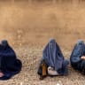 Women wearing burqas pause at the side of a road in Kabul, Afghanistan October 26, 2021.