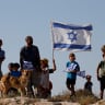  Jewish settlers look on during a march near Hebron in the West Bank, June 21, 2021