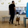  An Israeli man walks with his son to cast his ballot on the day of Israel's general election in a polling station in Rahat, Israel November 1, 2022.