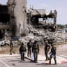  Israeli security gather near a rifle at the site of a battle following a mass infiltration by Hamas gunmen from the Gaza Strip, in Sderot
