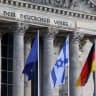  An Israeli flag flutters next to a German and a EU flag, one day after Hamas' attacks on Israel, outside the Reichstag building in Berlin, Germany, October 8, 2023. 