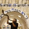  An illustrative photo of a man blowing a shofar, a ceremonial ram's horn, which is done repeatedly on Rosh Hashanah.