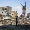  Palestinians walk next to a destroyed Mosque from an Israeli airstrike in the southern Gaza Strip, on September 9, 2024