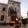  A Syrian anti government fighter shoots against a large banner bearing a picture of Syria's President Bashar al-Assad, hanging on the facade of a municipal building in the west-central city of Hama on December 5, 2024.