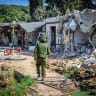  Israeli soldiers and journalists walk around the destruction caused by Hamas in Kibbutz Kfar Aza, November 2, 2023