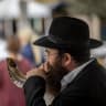 A man blows a shofar outside the Jerusalem Central Bus Station. 