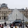 Police stand near the pyramid of the Louvre museum after reports of a robbery, in Paris, France, October 19, 2025.