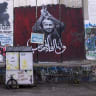 A Palestinian man walks past graffiti showing Palestinian political prisoner Marwan Barghouti in Bethlehem, West Bank.