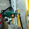 A worker fills benzene, at a gas station in Jerusalem before petrol prices rise at midnight on 31 January 2011.