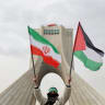 A person holds up an Iranian and Palestinian flag near Azadi Tower during the 47th anniversary of the Islamic Revolution in Tehran, Iran February 11, 2026.