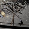 A cleric walks near a residential building damaged by a strike on March 4, in Tehran, Iran, April 14, 2026. 