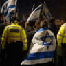 A woman draped in an Israeli flag stands next to police officers as she joins members of the Jewish community outside BBC Broadcasting House to demonstrate against the BBC's ongoing refusal to label Hamas as terrorists, in London, England, October 16, 2023; file photo.