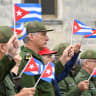 Cuba's President Miguel Diaz-Canel waves a Cuban flag alongwith others during a march outside the U.S. Embassy to protest against what they denounce as U.S. aggression in the region, following the capture of Venezuelan leader Nicolas Maduro and the killing of Cuban soldiers on January 16, 2026.