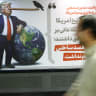 People walk past a caricature depicting US President Donald Trump, in Tehran, Iran, May 4, 2026. 