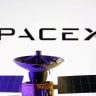 SpaceX logo and miniature satellite model are seen in this illustration taken, March 10, 2025.
